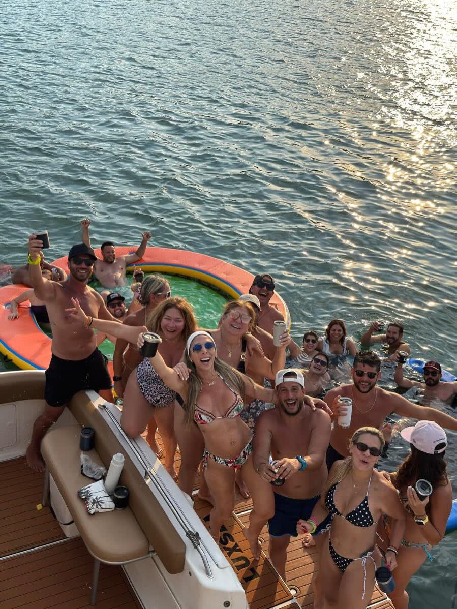 Friends sitting along the rail with the sun flaring off shallow bay water