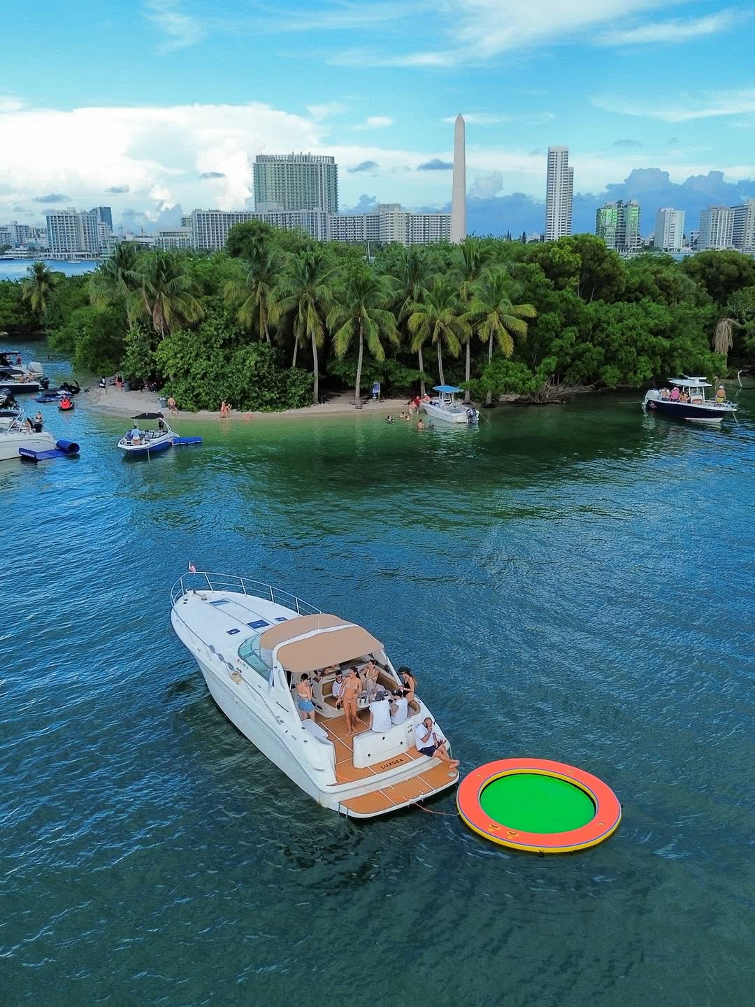 El Sea Ray Sundancer anclado frente a una isla de manglares con el skyline de Miami detrás