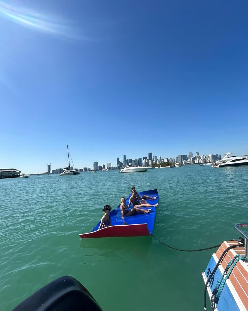 The boat pulled up to the sand with the blue float in the shallows